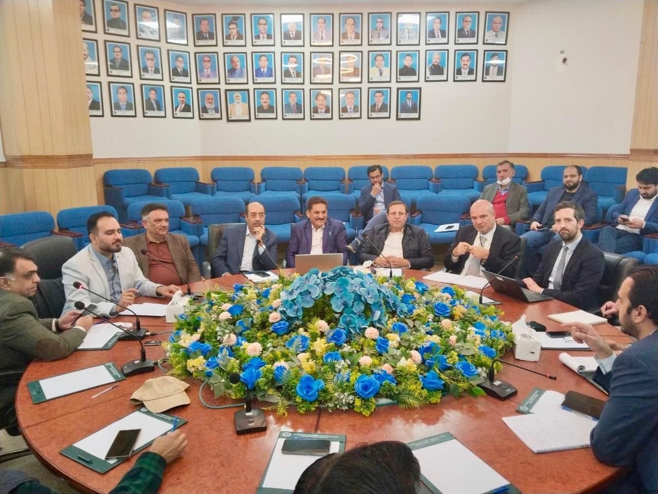 Conference meeting with participants around a table with blue flowers